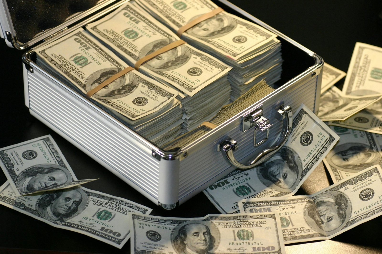 A metallic briefcase full of US dollar bills, symbolizing wealth and investment.